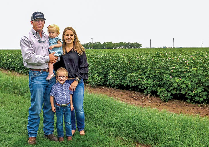 Photo by Janet Hunter. Central Texas Farm Credit customers Justin and Allison Strube with their daughter, Suede, and son, Stehl, on their home farm in Wall, Texas.